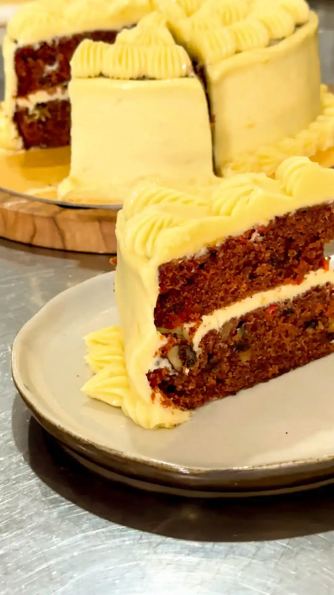 Carrot cake with cream cheese frosting, one slice cut