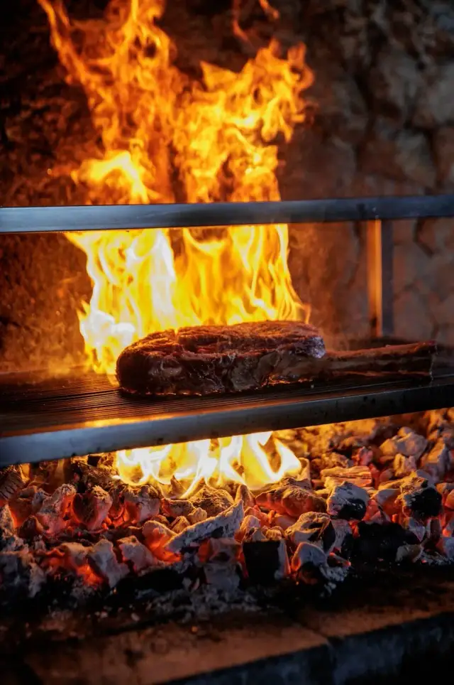 Flames climbing the wall of the open grill — Tabu Bali, frame 1 of 3