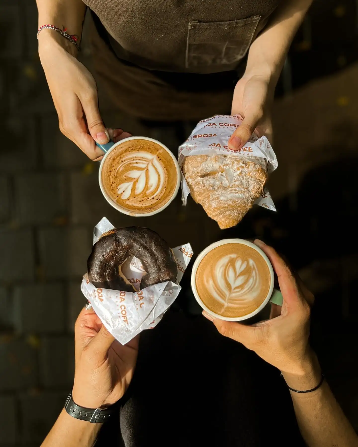 Dua cangkir latte art dan pastri dari atas, konten feed kafe