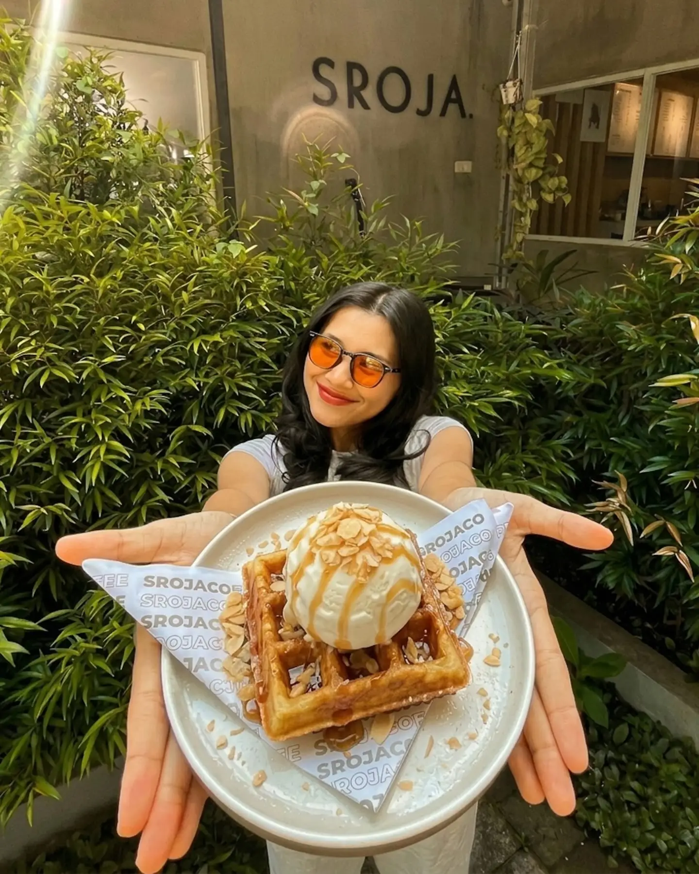 Pengunjung menyodorkan waffle dengan es krim di depan kafe