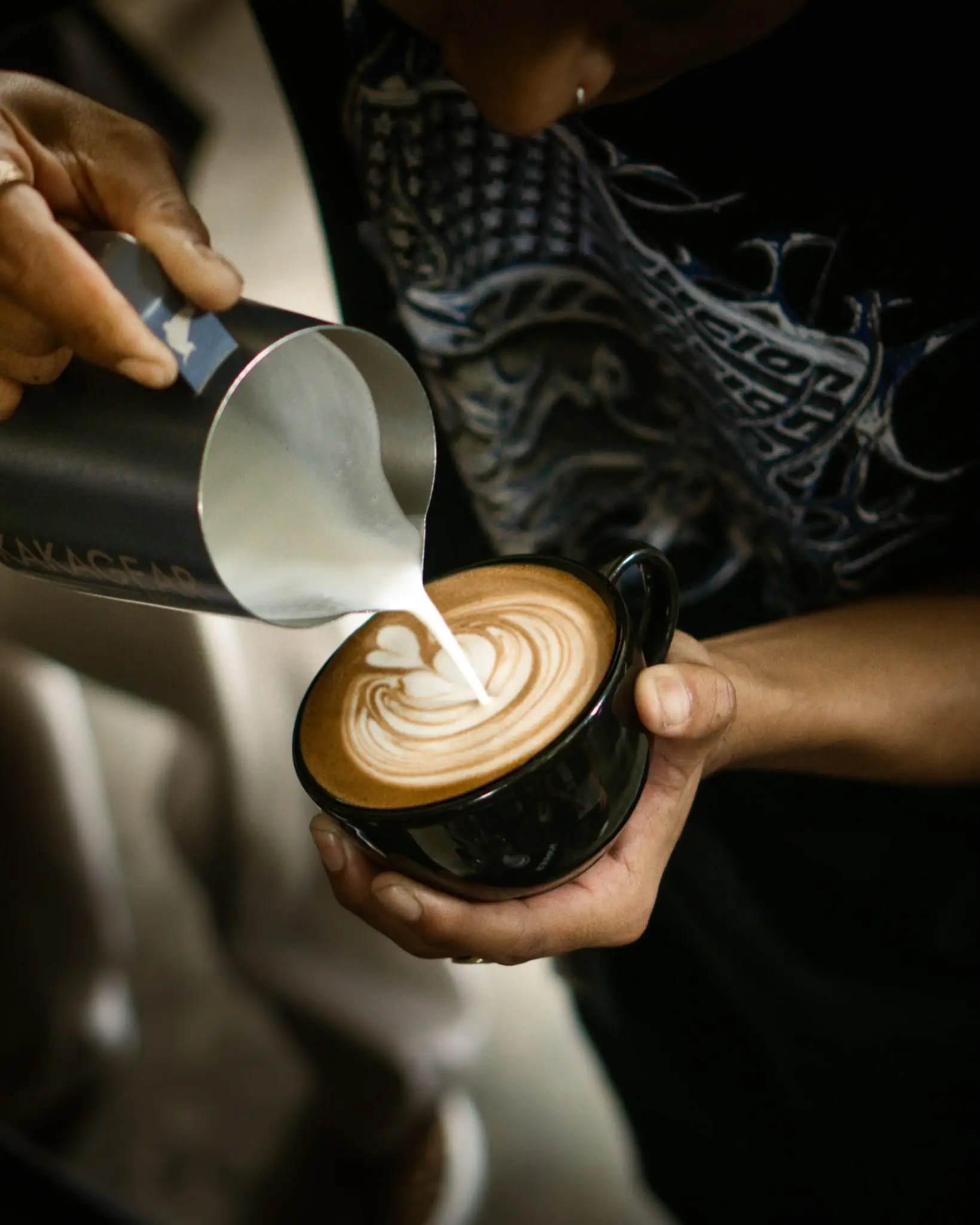 Barista menuang susu membentuk latte art